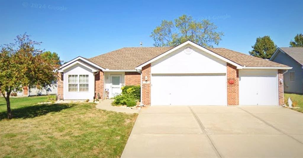 ranch-style home with a garage and a front yard