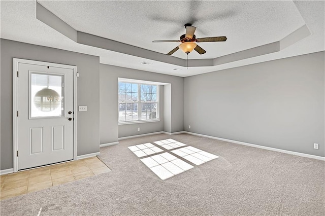 carpeted foyer entrance featuring ceiling fan, a raised ceiling, and a textured ceiling