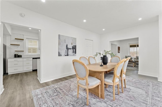 dining room with baseboards, light wood finished floors, and recessed lighting