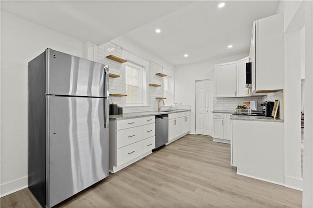 kitchen featuring stainless steel appliances, open shelves, white cabinetry, and light wood-style floors