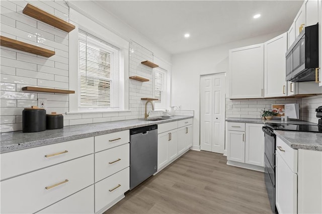 kitchen with light wood-style flooring, black electric range oven, stainless steel dishwasher, open shelves, and a sink