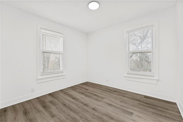 spare room with wood finished floors and baseboards