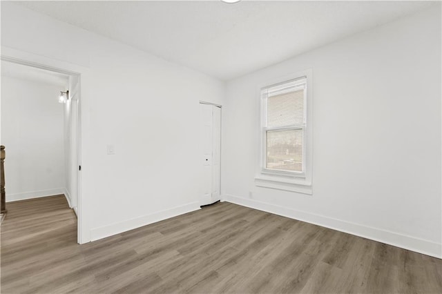 spare room featuring wood finished floors and baseboards