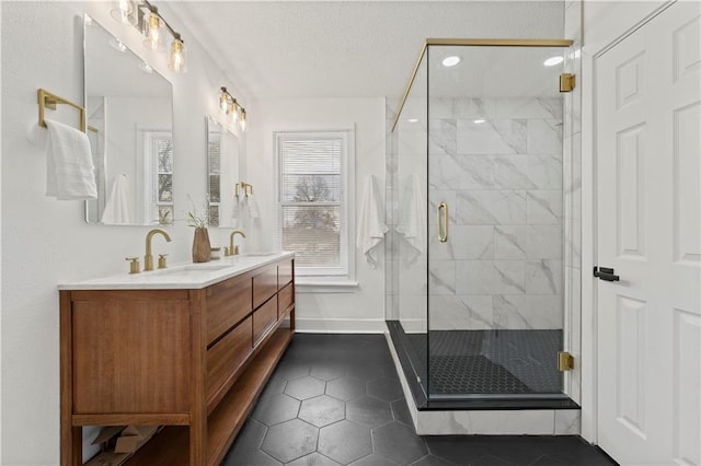 bathroom featuring double vanity, a stall shower, a sink, and tile patterned floors