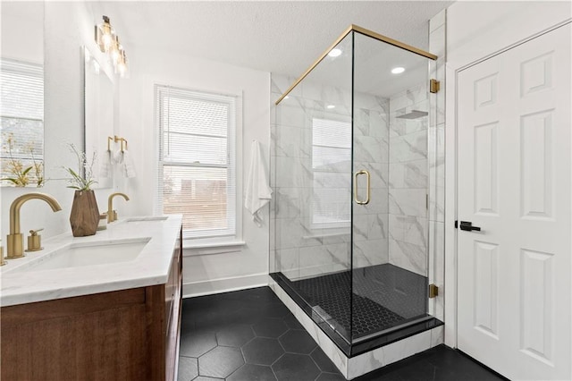 full bath with a shower stall, baseboards, a sink, and tile patterned floors