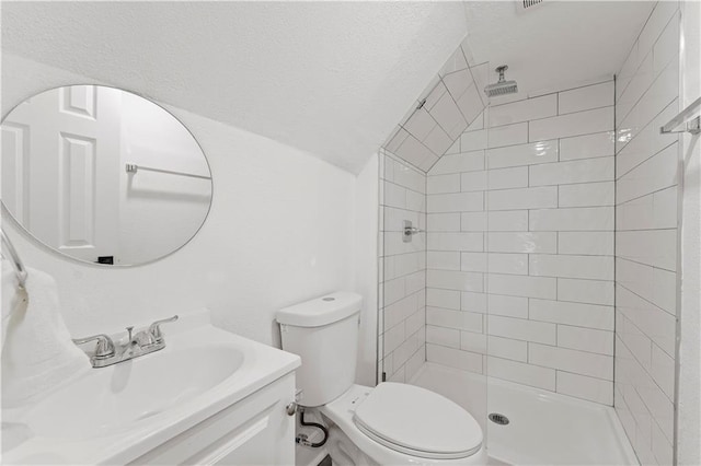 bathroom featuring toilet, a stall shower, vaulted ceiling, and vanity