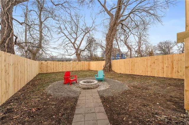 view of yard featuring a fenced backyard and a fire pit