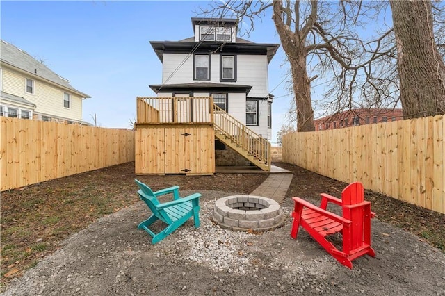 view of playground with a fenced backyard, stairs, and a fire pit