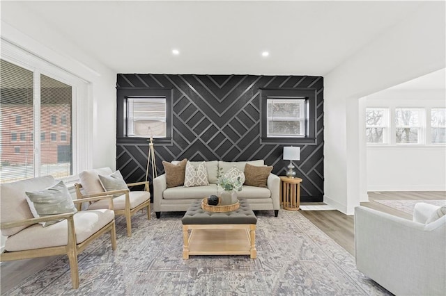 living area with recessed lighting, an accent wall, wood finished floors, baseboards, and wallpapered walls