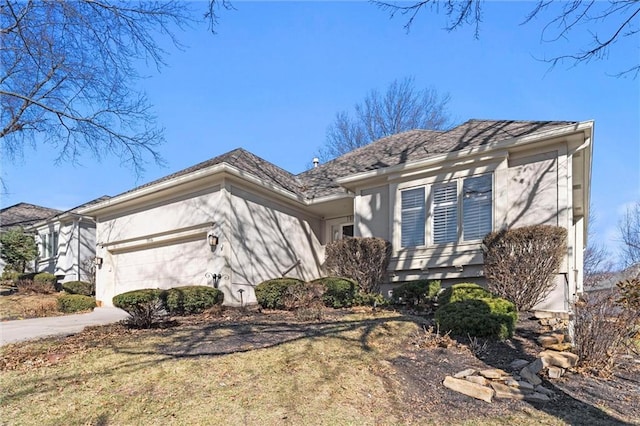 view of front of home with driveway, an attached garage, and stucco siding