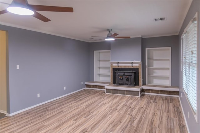 unfurnished living room with crown molding, wood-type flooring, and built in shelves