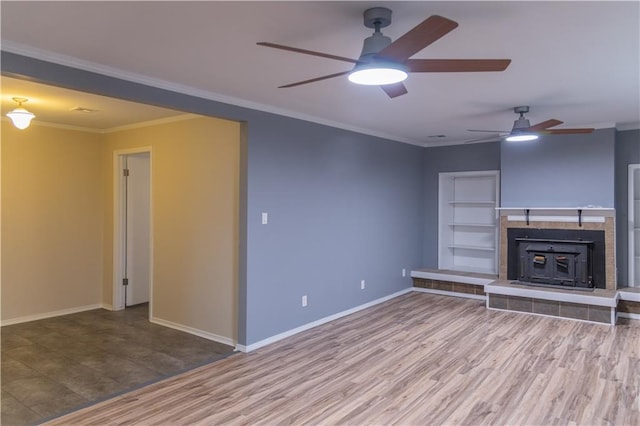 unfurnished living room featuring a tiled fireplace, hardwood / wood-style flooring, and ornamental molding