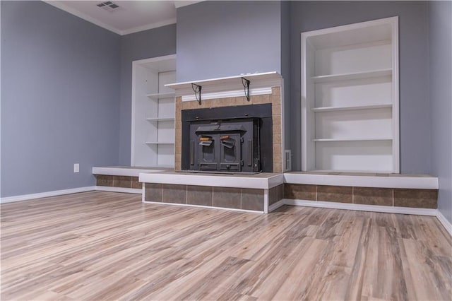 unfurnished living room with ornamental molding, built in features, and light hardwood / wood-style flooring