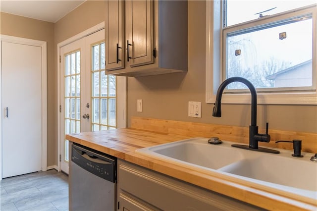 kitchen with gray cabinetry, sink, stainless steel dishwasher, and french doors