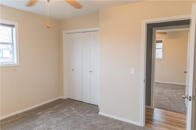 unfurnished bedroom with hardwood / wood-style flooring, a closet, ceiling fan, and multiple windows