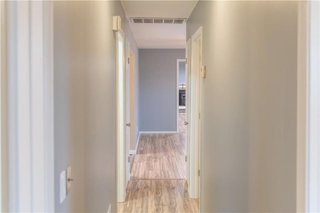 hallway with light hardwood / wood-style floors