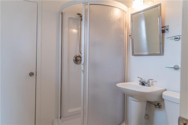 bathroom with toilet and a shower with shower door