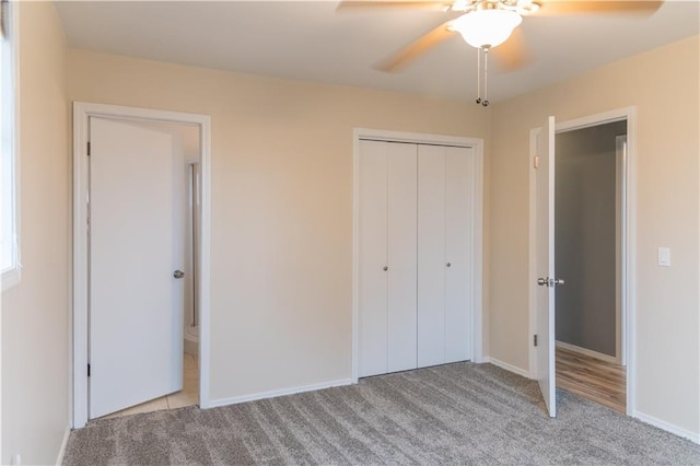 unfurnished bedroom featuring light colored carpet, a closet, and ceiling fan