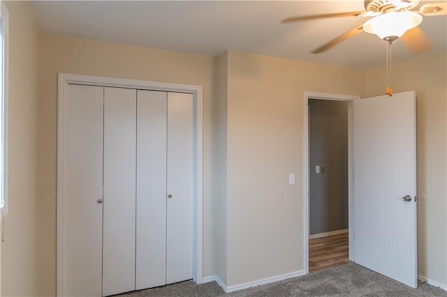 unfurnished bedroom with ceiling fan, carpet flooring, and a closet