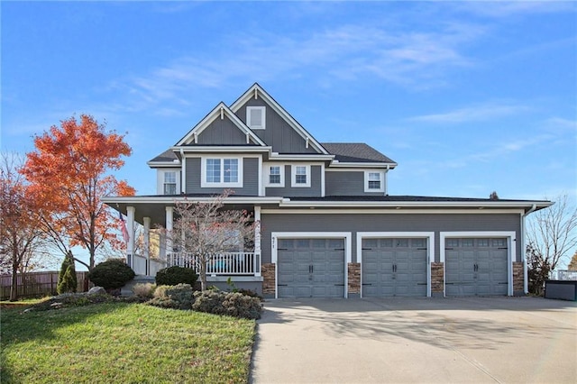 view of front of house featuring a garage, a front lawn, and a porch