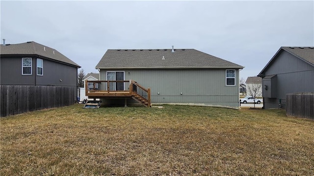 back of house featuring a deck and a lawn