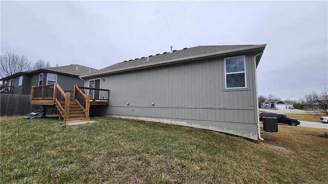 back of property featuring a wooden deck and a lawn