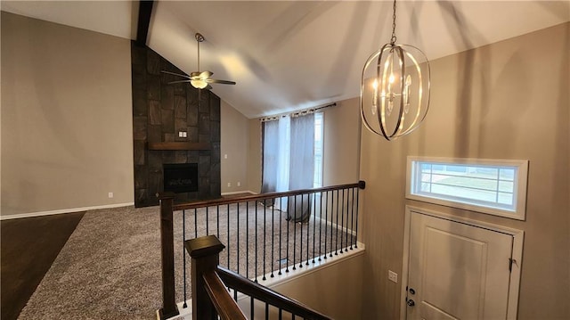 interior space featuring ceiling fan with notable chandelier, a fireplace, high vaulted ceiling, and dark colored carpet