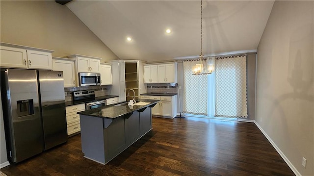 kitchen featuring stainless steel appliances, an island with sink, pendant lighting, and white cabinetry