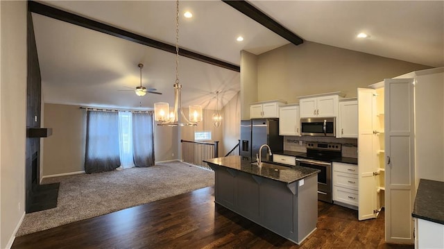 kitchen featuring a center island with sink, beamed ceiling, white cabinets, and appliances with stainless steel finishes