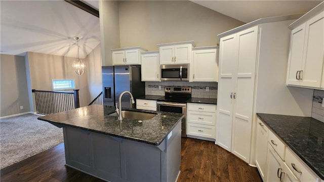 kitchen with dark stone countertops, sink, stainless steel appliances, and white cabinets