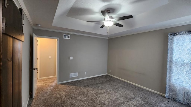 carpeted empty room featuring crown molding, ceiling fan, and a tray ceiling