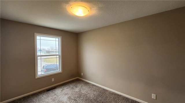 unfurnished room with carpet floors and a textured ceiling