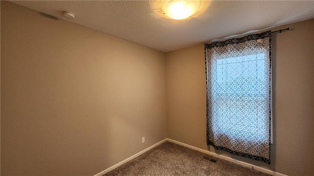 carpeted spare room featuring a textured ceiling