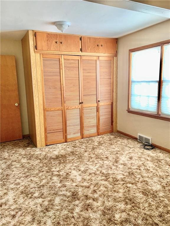 unfurnished bedroom featuring carpet and a closet