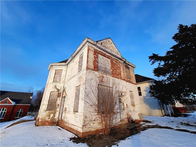 view of snow covered exterior with brick siding