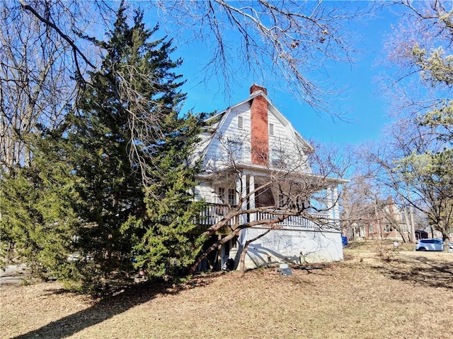 view of side of home with a gambrel roof