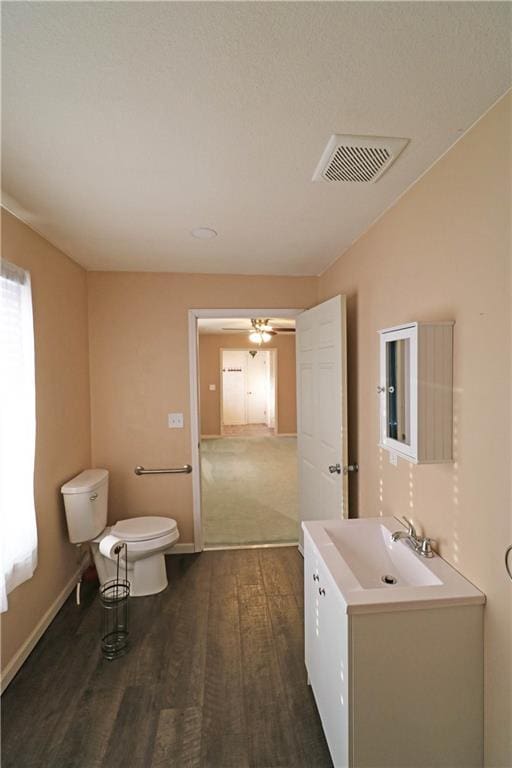 bathroom featuring vanity, hardwood / wood-style floors, ceiling fan, and toilet