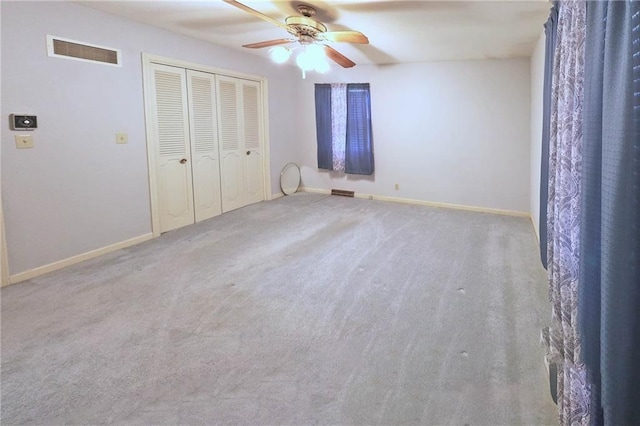 unfurnished bedroom featuring ceiling fan, a closet, and carpet