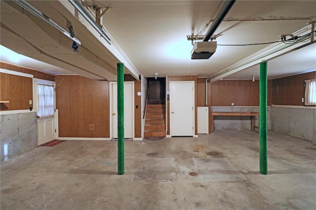 garage with a garage door opener and wooden walls