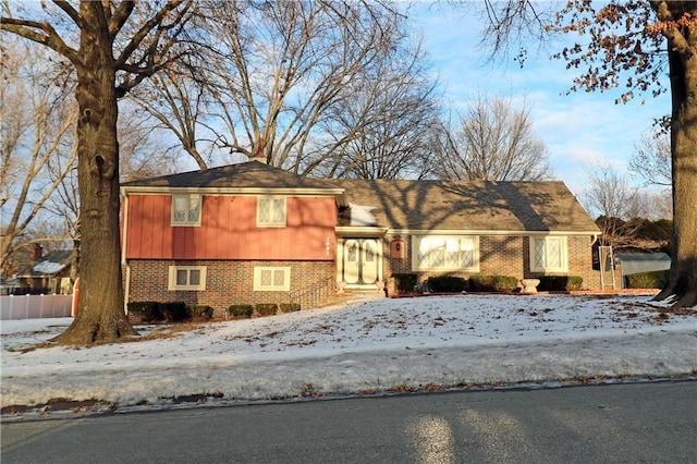 tri-level home with brick siding and fence