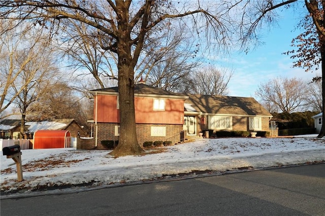 split level home with brick siding and fence