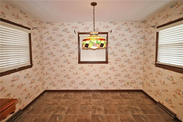 unfurnished room with wallpapered walls and baseboards