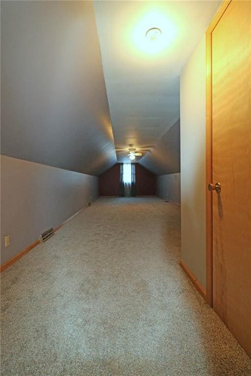 additional living space with baseboards, lofted ceiling, and carpet flooring