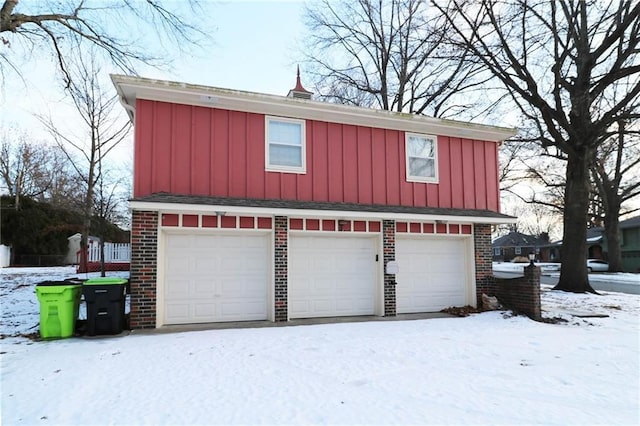 snow covered garage with a garage