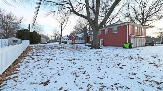 yard covered in snow featuring a residential view and fence