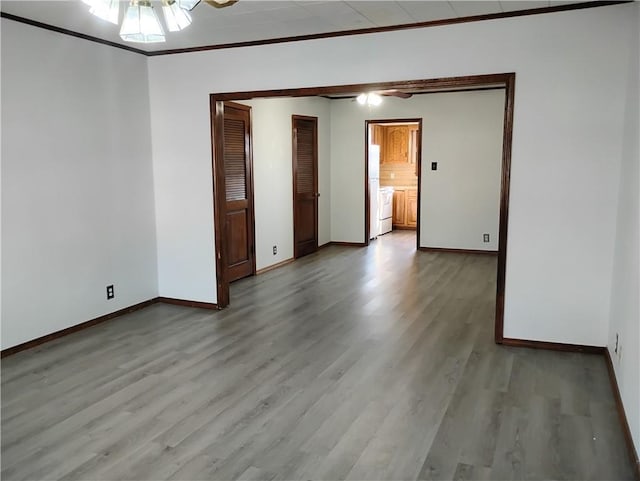 spare room featuring ceiling fan, ornamental molding, and light wood-type flooring