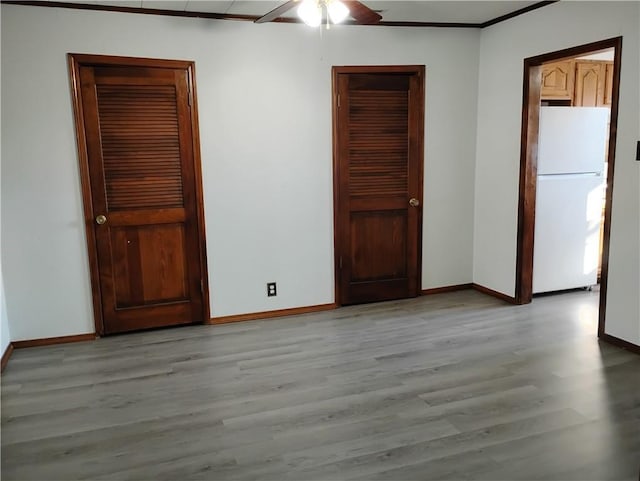 empty room featuring light wood-type flooring, ceiling fan, and ornamental molding