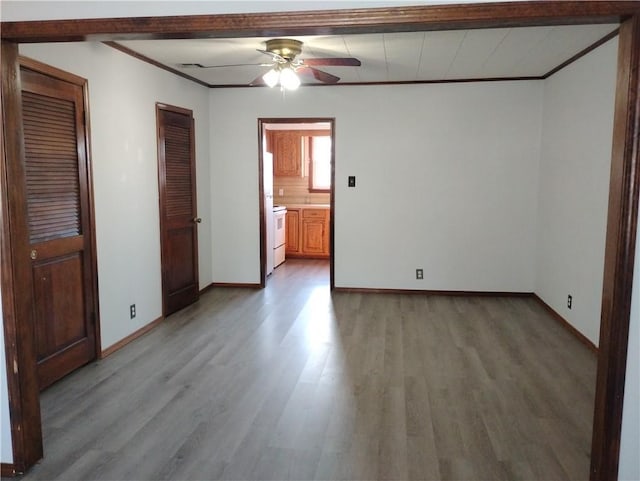 spare room with crown molding, hardwood / wood-style flooring, and ceiling fan