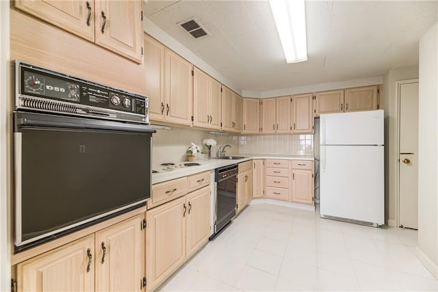 kitchen with light brown cabinetry, sink, decorative backsplash, and black appliances