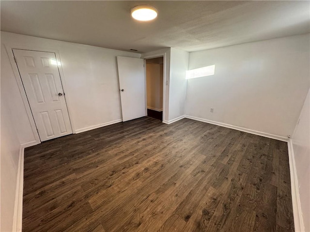 unfurnished room featuring dark wood-type flooring